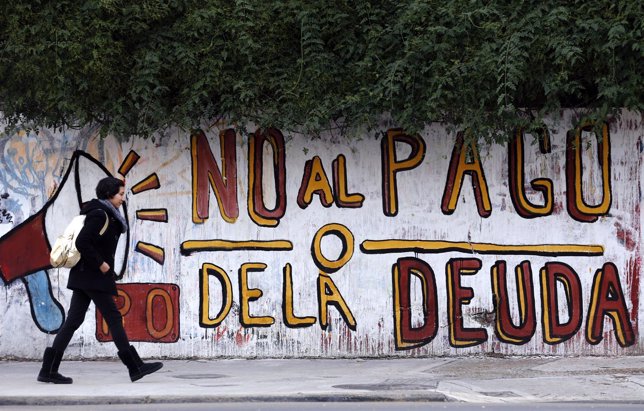 A woman walks past a graffiti in Buenos Aires