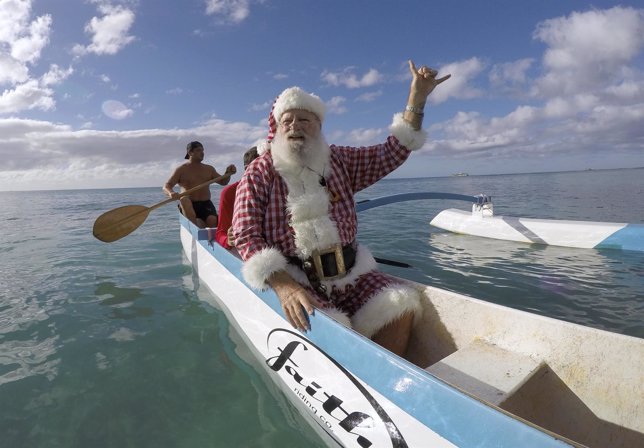 Donald Boyce, vestido como Papa Noel, llega a la playa de Waikiki (Hawai)
