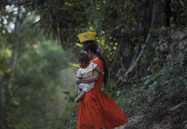 A Ch'orti' woman and a baby walk in Carrizalon