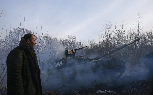 A man stands next to a pro-Russian separatist's tank riding near the village of 