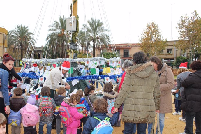 Algunos niños de Alcalá de Guadaíra junto a sus profesoras adornando el árbol.