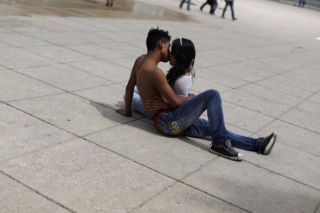 Una pareja joven se besa en un parque de México, jóvenes, heterosexuales