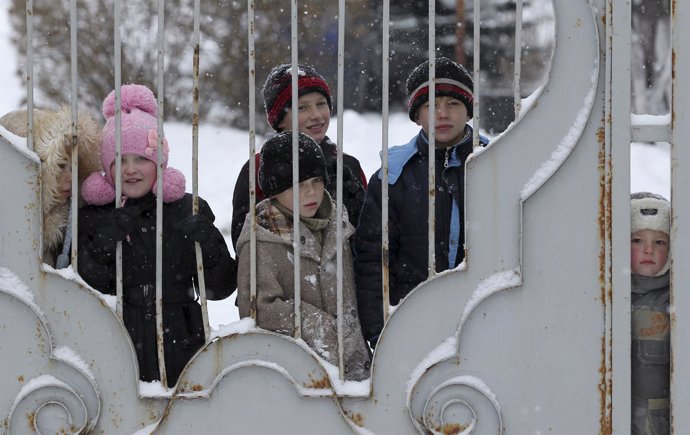 Menores ven la llegada de un convoy humanitario ruso en Donetsk