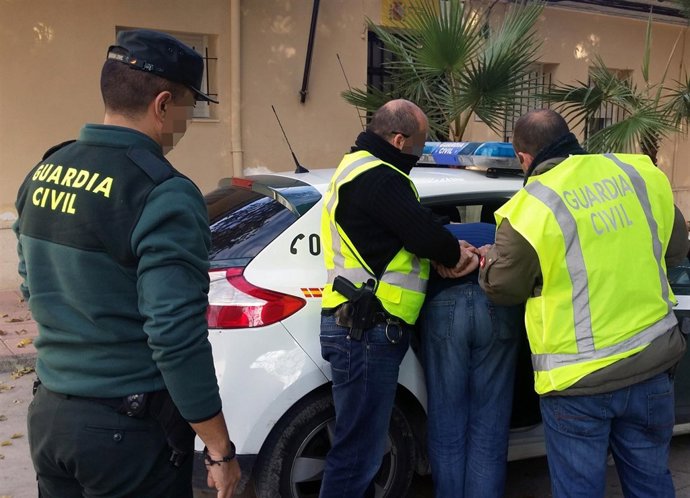 Imagen del detenido, introducido en un coche patrulla