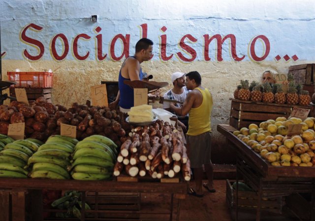 Vendors wait for customers at their stalls, with prices tagged in Cuban pesos, a