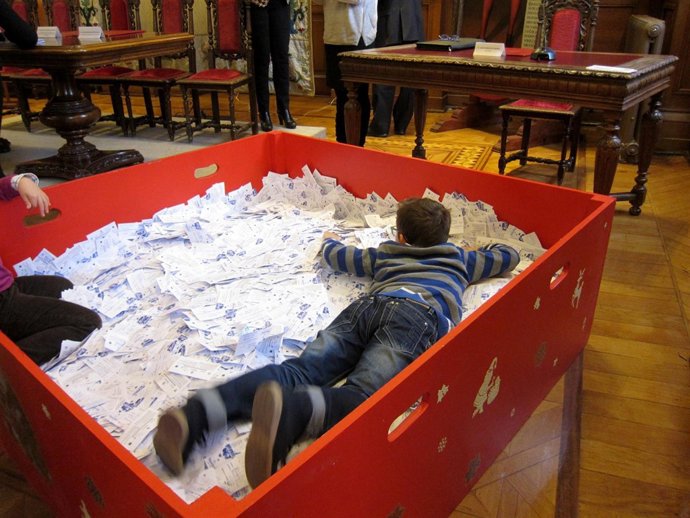 El niño encargado de sacar las papeletas, 'nadando' entre ellas. 