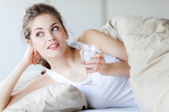 Woman ocho vasos de agua al día, una rutina diaria síntoma de belleza y salud