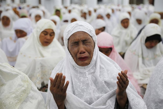 Una mujer indonesia llora durante el rezo masivo por las víctimas del tsunami