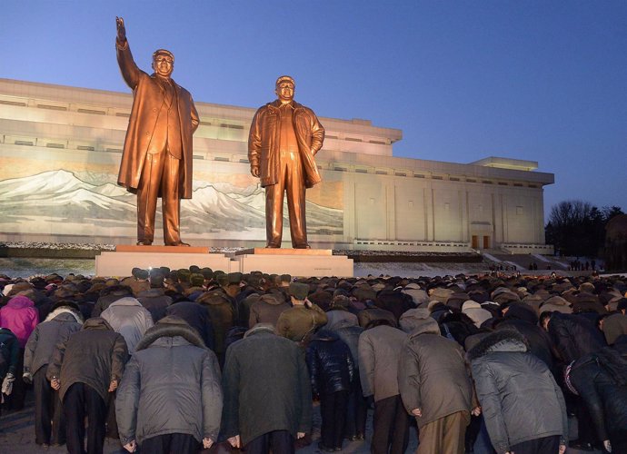 Norcoreanos rindiendo homenaje a Kim Jong Il y Kim Il Sung