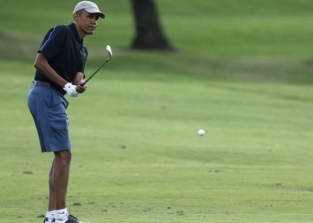 U.S. President Barack Obama chips onto the 18th green as he finishes a round of 