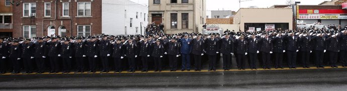 Agentes de Policía de Nueva York saludan al féretro de su compañero asesinado
