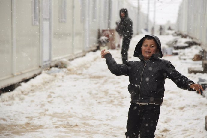 Un niño desplazado yazidí juega con la nieve en Dohuk (Irak)