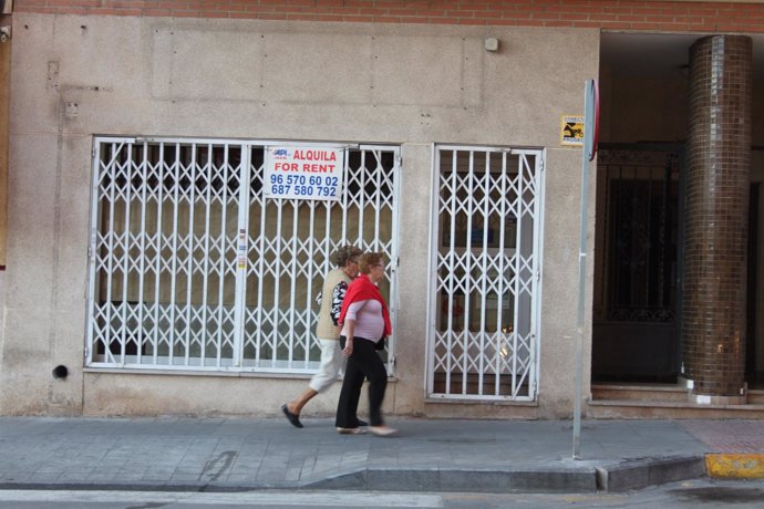 Dos mujeres pasan delante de un comercio cerrado en Torrevieja