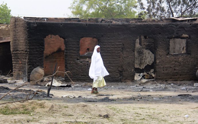 Una mujer entre los restos tras el ataque al pueblo de Baga