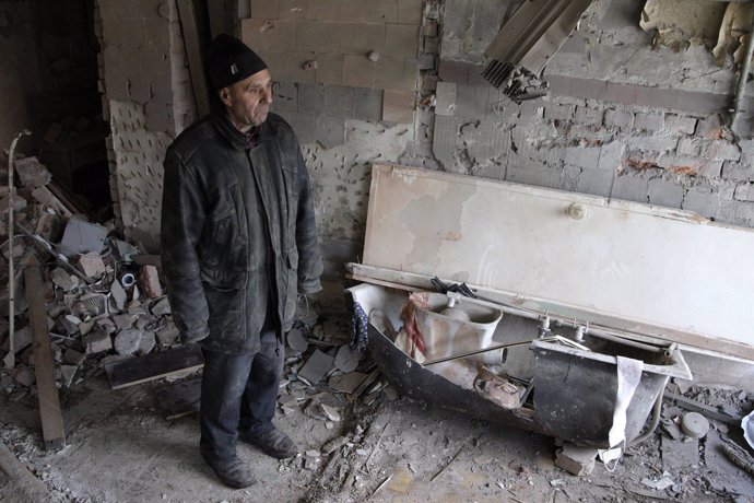 Un hombre mira su casa derruida en Donetsk, este de Ucrania