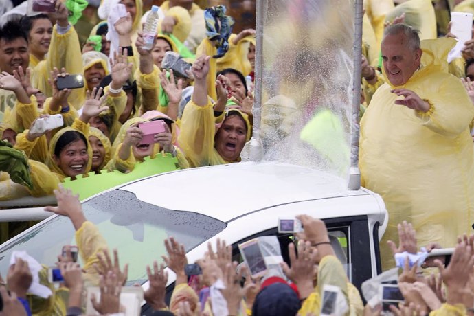 El Papa saluda a la multitud bajo la lluvia