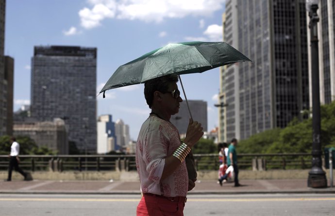 Un hombre se protege del sol con un paraguas en un día caluroso en Sao Paulo