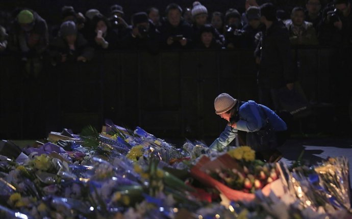 Una mujer deposita una vela en el lugar de la estampida en Shanghai
