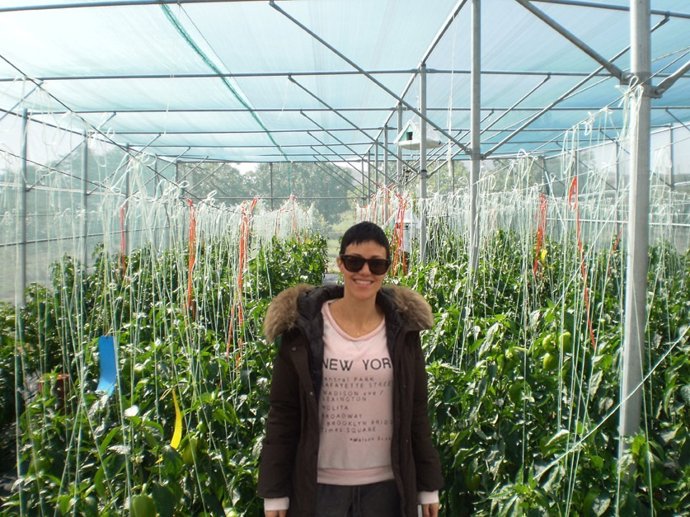 En la imagen, la autora de la tesis, en los invernaderos con malla