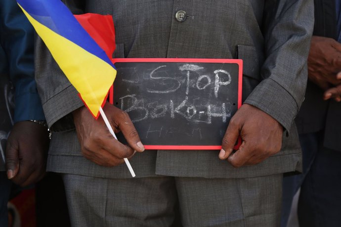 A man holds a sign that reads "Stop Boko Haram"