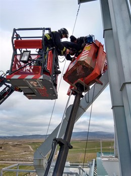 Momento en el que un bombero coloca el arnés de seguridad al operario.