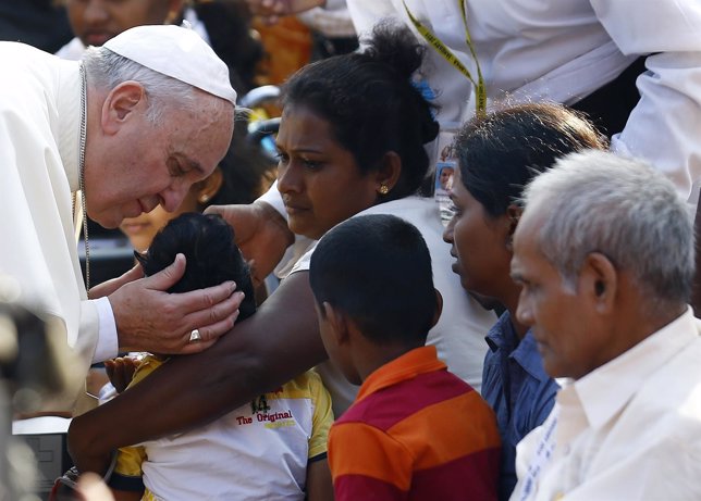 El Papa Francisco bendice a un niño.