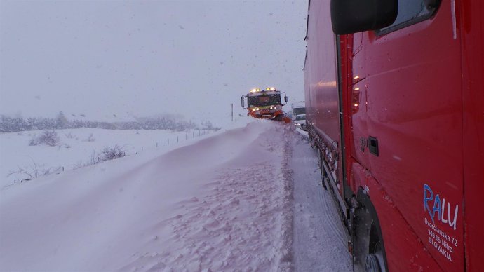 Camiones en la carretera con nieve en Cantabria. Temporal. Tráfico cortado. 