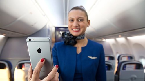 Azafata con iPhone 6 en la mano.