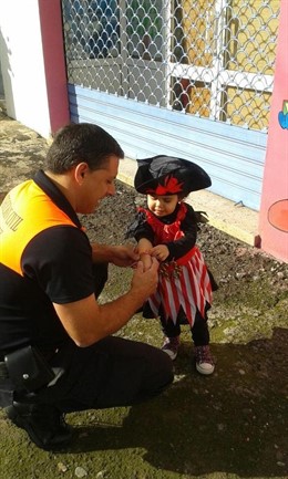 Un miembro de Protección Civil pone una pulsera a una niña