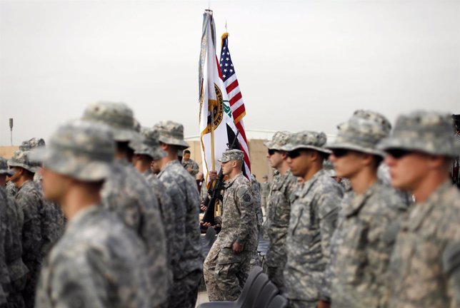 U.S. Soldiers carry an U.S. National flag, an Iraq national flag, and the U.S. F