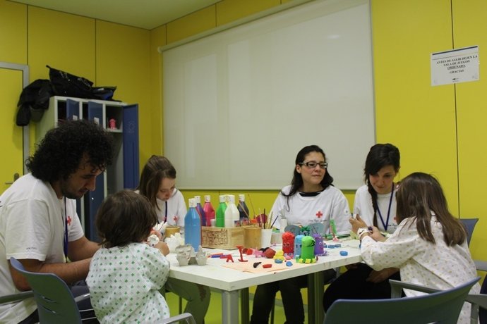 Voluntarios de Cruz Roja, con niños hospitalizados.