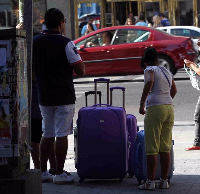 Turismo, turistas, personas en la calle con maletas