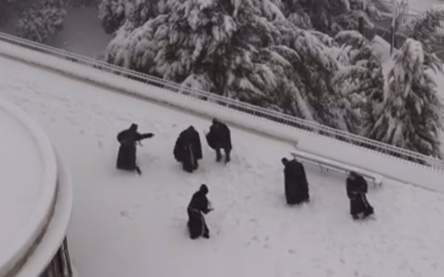 Monjes franciscanos jugando con la nieve