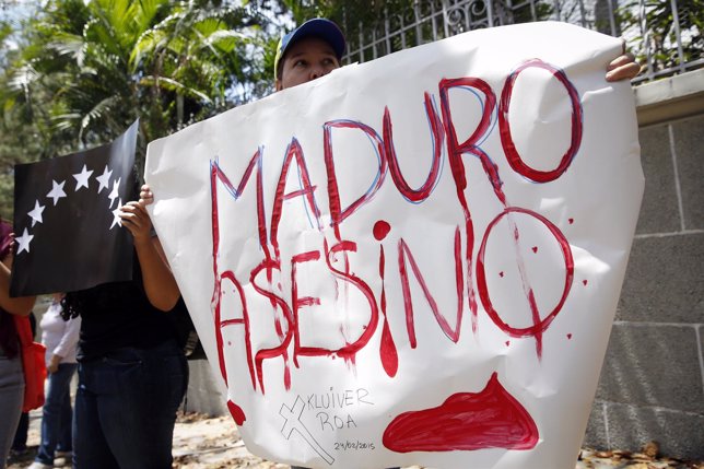 Opposition supporter holds a sign during a gathering to protest the death of an 