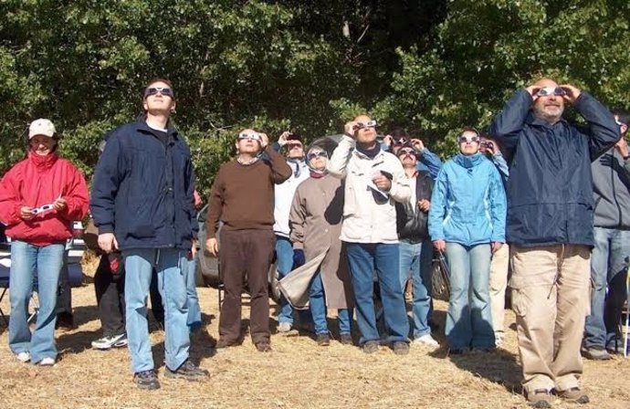 Gente mirando un eclipse de sol