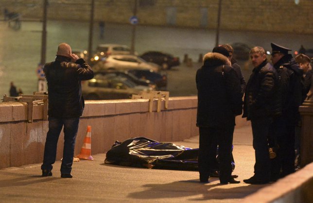 Investigators gather near the covered body of Boris Nemtsov in central Moscow