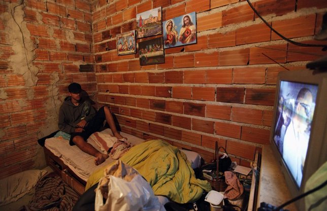 Habitante de una favela viendo la televisión.