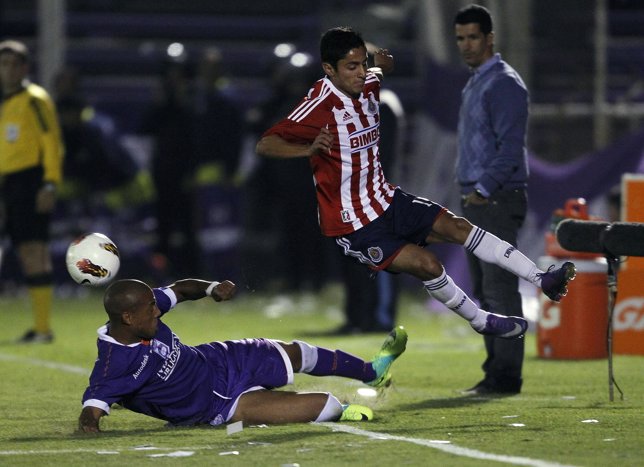 Pintos of Defensor Sporting competes for ball with Nava of Chivas during their C