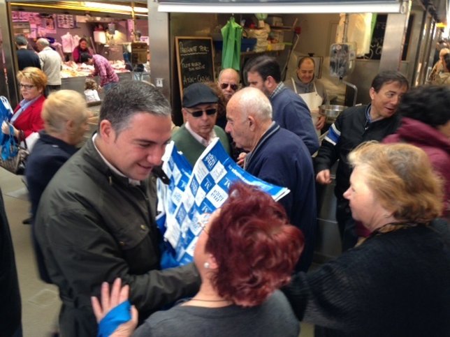 Elías Bendodo atiende a mujeres en el mercado de atarazanas