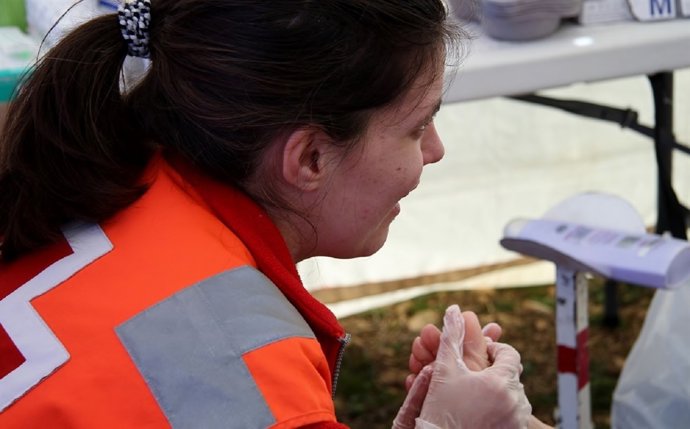 Delegada de Cruz Roja atendiendo a un peregrino