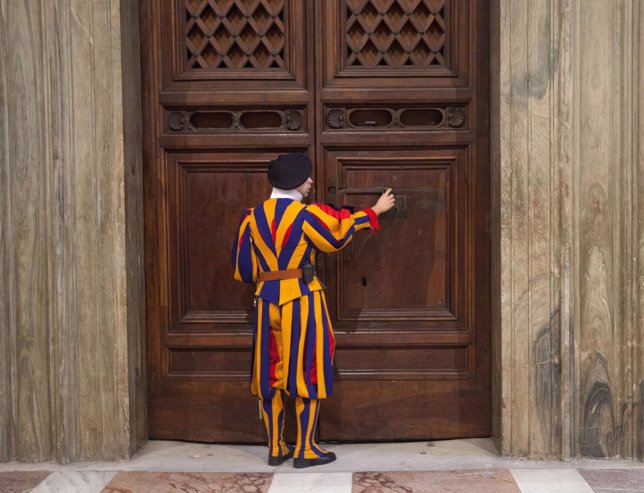 A member of the Swiss Guard unlocks a door to the Sistine Chapel during U.S. Sec
