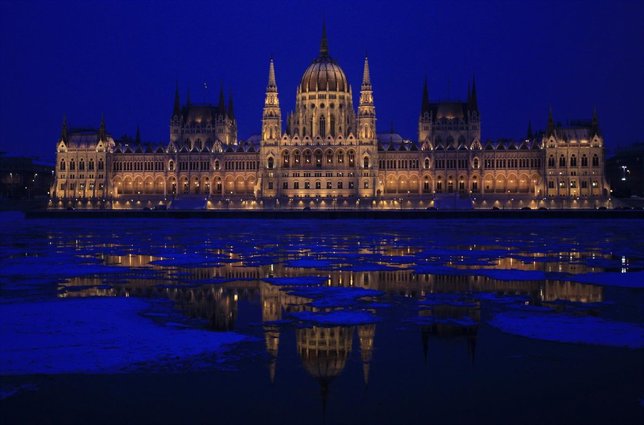 The Hungarian Parliament building is reflected on the icy Danube river in Budape