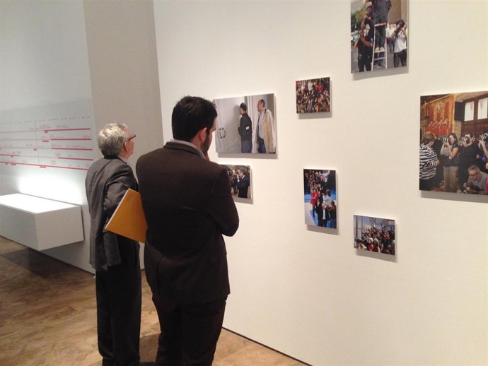 Gente observa la exposición fotográfica 'Fragments' en La Nau