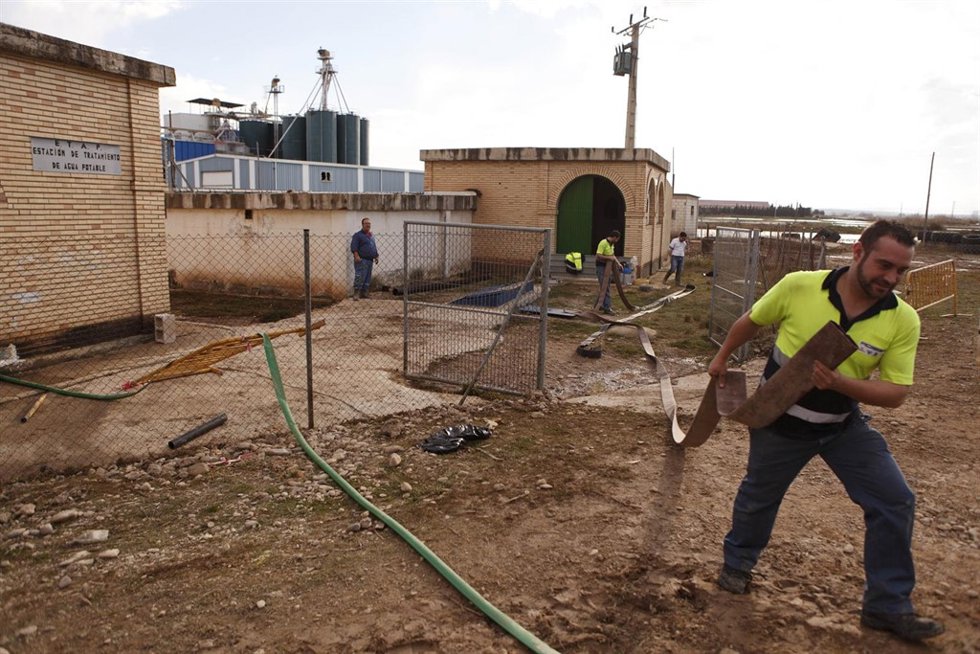 Operario con una manguera para achicar agua en Boquiñeni