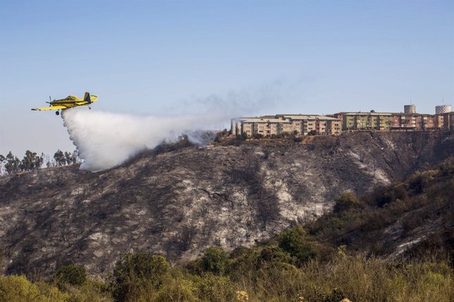 Plane assists in putting out a forest fire at the hills in Valparaiso city