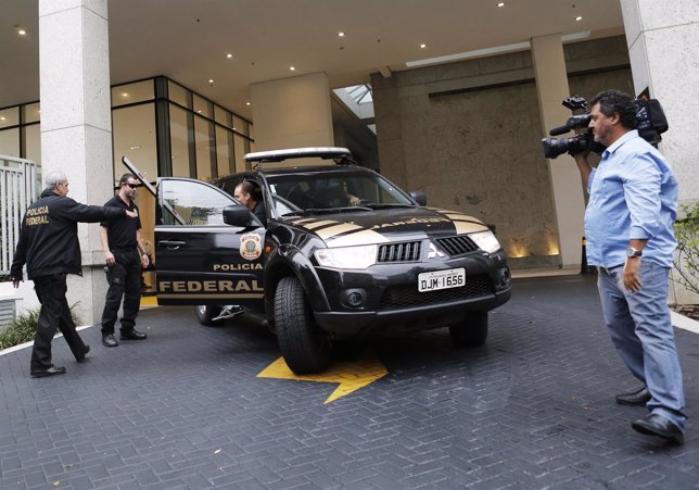 Federal police enter a vehicle as they leave the headquarters of Brazilian congl