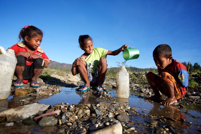 Niños juegan con agua en  Timor Oriental