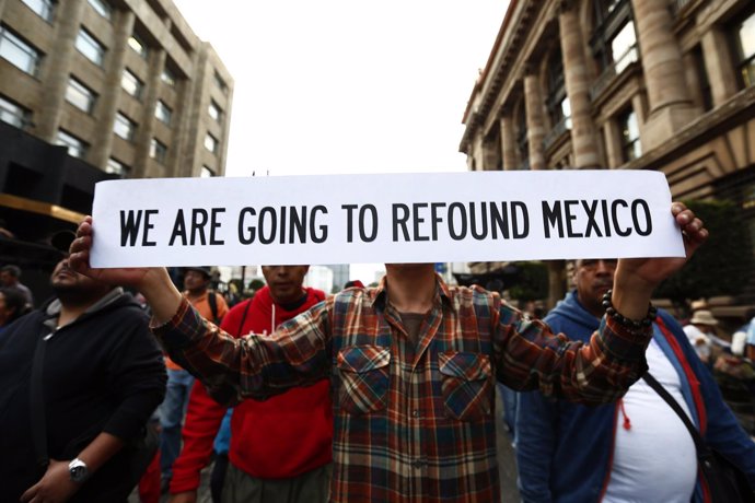 An activist holds a poster while demanding justice in Mexico City