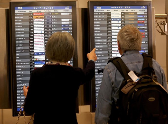 Pasajeros consultando tiempos de salida en aeropuerto