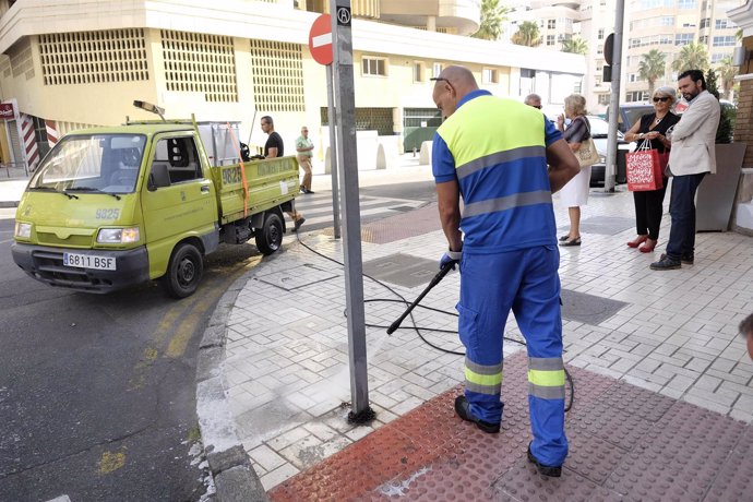 Un operario de Limasa limpia una señal de tráfico limpieza suciedad málaga